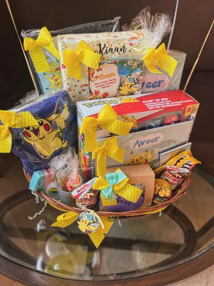 Another view of the overflowing Pokémon hamper, showcasing the bright yellow bows and a mix of toys and treats for the birthday boy.