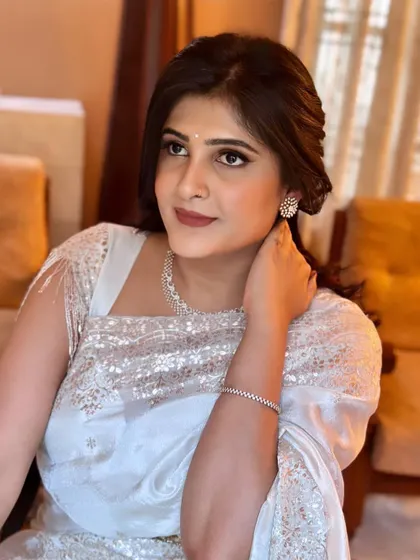 An elegant evening look in a stunning white sequin saree. The makeup is focused on a classic winged liner and a warm, neutral lip color.