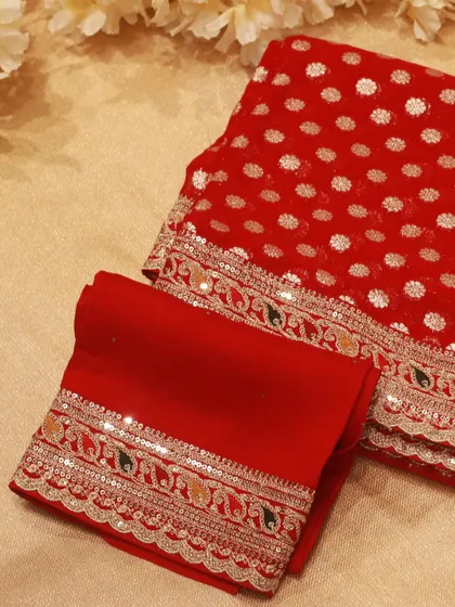 The saree comes with a matching embroidered blouse piece, completing the luxurious look.