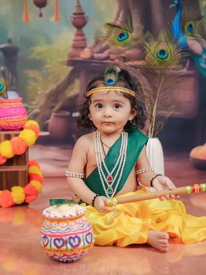 A serene portrait of a baby Krishna, holding his flute against a backdrop of peacocks. I focus on creating a calm environment to capture these peaceful moments.