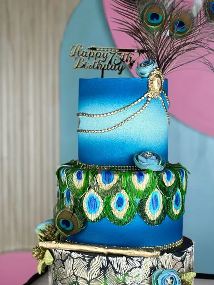Crafted with love for a special 75th birthday. This Krishna-themed cake features vibrant peacock feather details in blue and green, celebrating a lifetime of wisdom and joy.