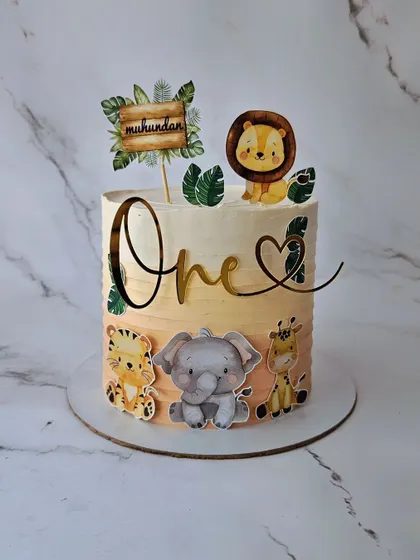 A jungle cake in a beautiful peach ombre. This butterscotch cake for Mukundan's first birthday uses edible prints to create a soft and sweet safari theme.