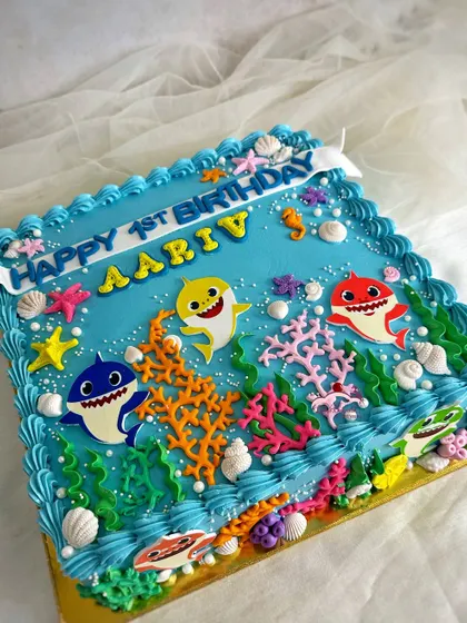 A close-up of the square Baby Shark cake, with vibrant colors and lots of underwater details.