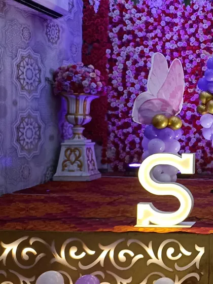 A close-up of the butterfly-themed balloon accent and the 'S' marquee letter on the stage.