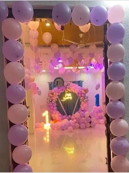 A view from the doorway of a room completely transformed for a first birthday. The purple and pink balloon decor creates an immersive and festive atmosphere from the moment you enter.
