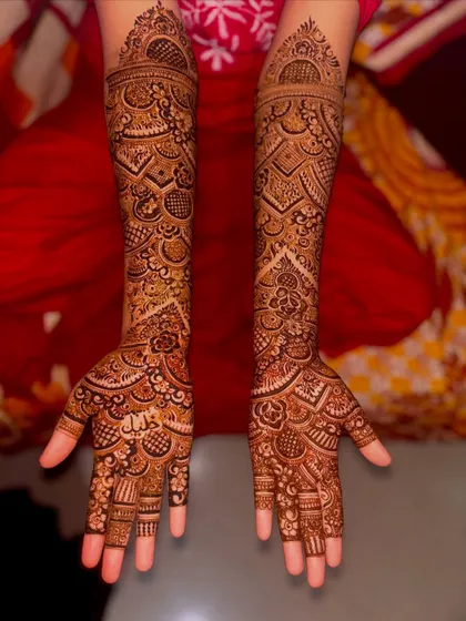 A classic full bridal mehndi design. The arms are covered in a dense pattern of traditional Indian motifs, perfect for a bride who wants a timeless and elegant look.