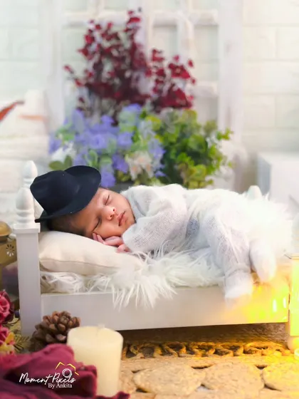 Dreaming big from his tiny bed. This creative newborn setup with a miniature bed and a little hat is a whimsical way to capture this fleeting stage.