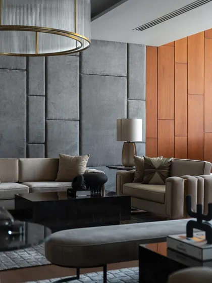 This contemporary living space embodies sleek lines and a seamless blend of comfort and style, featuring a custom upholstered wall that adds texture and acoustic comfort.