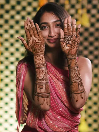 A happy bride showing off her intricate peacock and elephant mehendi. Even on slender hands, a full design looks absolutely stunning.