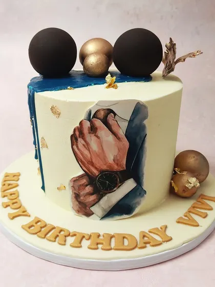 We design a cake for the modern gentleman. This sophisticated birthday cake features a painted image of a man adjusting his suit, complemented by a deep blue drip, gold leaf, and dark, elegant spheres for a truly distinguished look.