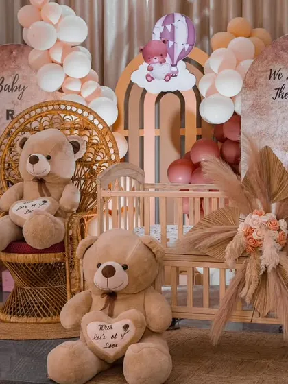 A close-up of the teddy bear rice ceremony, showing the charming details like the miniature cradle and the "We Love You To The Moon And Back" sign.
