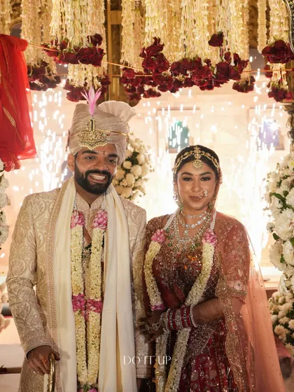 The happy couple, framed by the grand, traditional mandap and a shower of celebratory fireworks. A truly magical moment that we were honored to design.