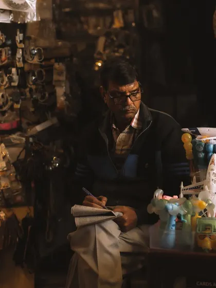 A quiet moment as a shopkeeper takes a break to do his accounts. Even in a crowded place, you can find these pockets of calm and solitude to photograph.