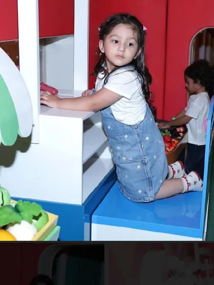 A young girl plays in the pretend market stall.