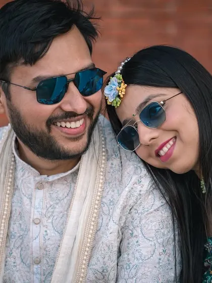 A sweet, candid moment between the couple during their Haldi. Their matching smiles and sunglasses show their fun-loving connection.