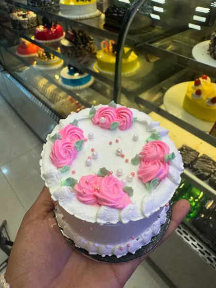 A white mini cake with pink rosette piping. This design is sweet and charming, perfect for a small celebration or as a delightful personal treat.