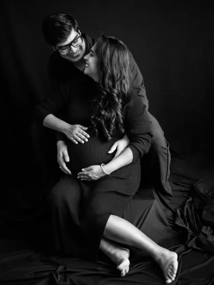 An intimate black and white portrait of the couple. The soft embrace and gentle expressions convey a deep sense of love and partnership on their journey to parenthood.