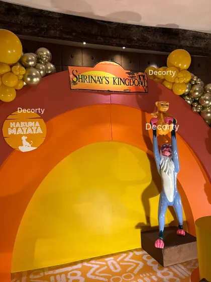 A close-up of the iconic Rafiki presenting Simba scene on the main stage backdrop.