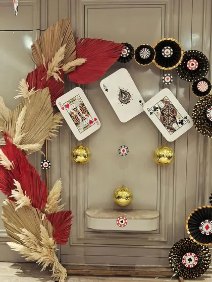 A stylish and modern take on a Diwali card party. We used giant playing cards, casino chip-themed paper fans, and dried palm leaves to create a unique and sophisticated backdrop for a festive get-together.
