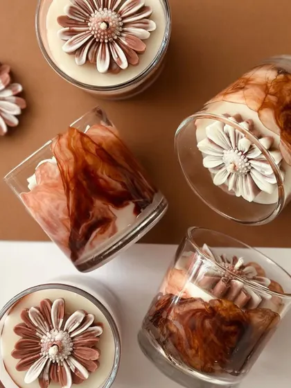 Experimenting with new styles. This is my coffee gradient design, where I swirled coffee-colored wax in a glass and topped it with a signature daisy.