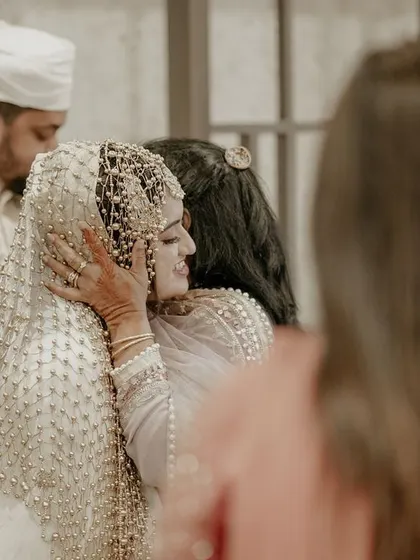 A touching, emotional embrace between the bride and a family member, capturing the bittersweet feelings of the day.
