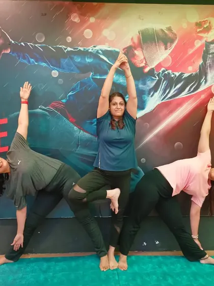 A beautiful group pose combining Tree Pose (Vrikshasana) and Triangle Pose (Trikonasana), showing the harmony and balance of our yoga community.
