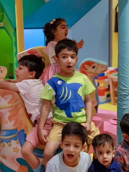 A group of excited children enjoying the mini carousel during a fun-filled unicorn birthday party.