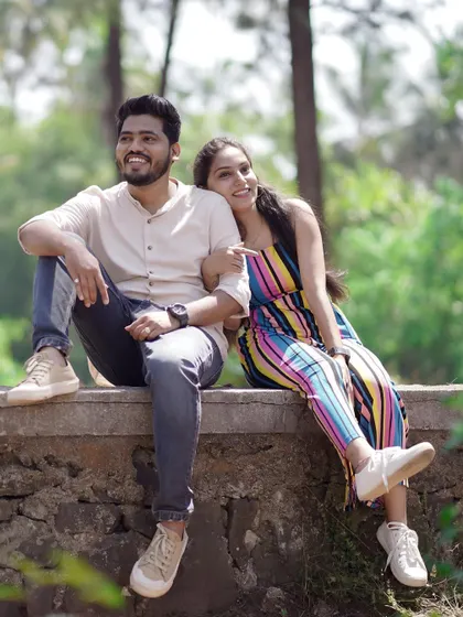 A relaxed and happy shot of the couple sitting on a stone wall. It’s a perfect example of a casual and comfortable pre-wedding portrait.