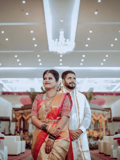 A classic wedding reception look. The couple stands against a beautiful floral wall, ready to greet their guests in a hall that I've decorated to feel grand and welcoming.