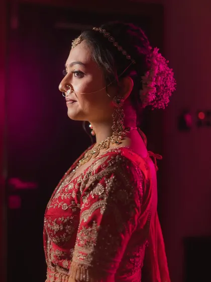 A profile shot highlighting the elegant bridal bun adorned with fresh flowers.