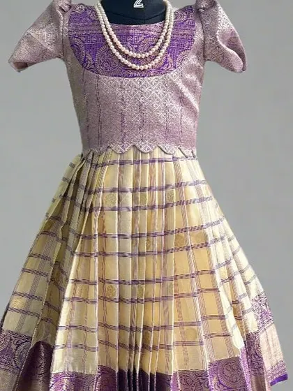 This kids' lehenga showcases a beautiful checkered pattern on the skirt with a rich purple brocade blouse and border. It's a timeless design made from a semi-Kanchi saree, perfect for your little one.