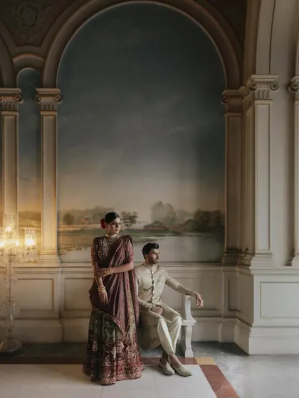 A stunning portrait of a couple at the Taj Falaknuma, framed by a magnificent painted archway. The grandeur of the setting elevates the image to a work of art.