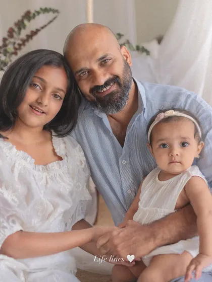 A father's love for his two daughters, his lifelines. This touching portrait captures the strong, gentle bond between a dad and his girls in a simple, beautiful setting.
