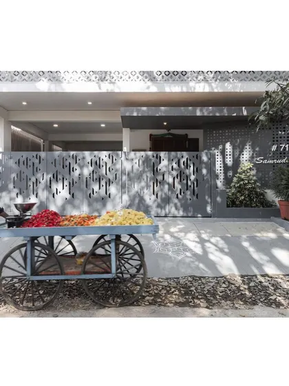 The home's modern facade provides a striking backdrop to the vibrant, traditional flower cart, a beautiful juxtaposition of old and new India.