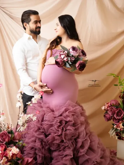 Love in full bloom. This couple's portrait is framed by beautiful flowers, with the ruffled mauve gown creating a stunning mermaid silhouette.