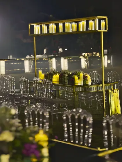 A unique dining table setup with an overhead structure holding a row of candles. This modern take on a candelabra adds height and drama to the tablescape.
