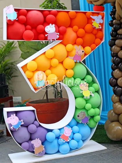 A rainbow-colored number '3' balloon mosaic decorated with Peppa Pig and friends, making a fantastic centerpiece for a third birthday.