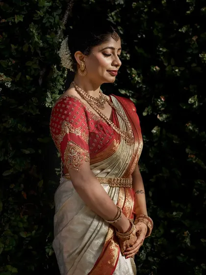 The rich texture of the Kanjivaram silk and the detailed gold embroidery on the blouse are highlighted in this beautiful portrait. This is a timeless look that will be cherished for generations.