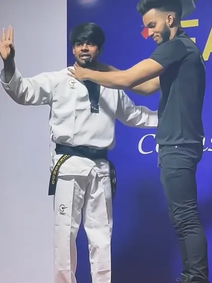 This image shows a demonstration of how to defend against a frontal choke or grab. It is a common attack, and knowing the escape is crucial.