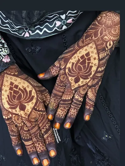 The lotus motif is a classic and one of my favorites to draw. I design it to be the centerpiece of the palm, using negative space to make the lotus symbol stand out, surrounded by delicate, traditional Indian henna patterns.