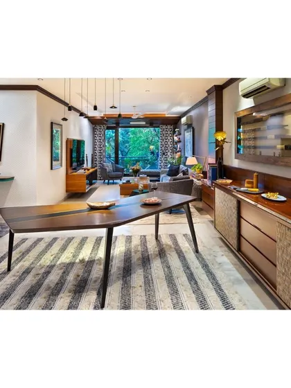 The boomerang-inspired dining table at Treetops, paired with a custom buffet counter. This view showcases how we design spaces for flow, where each piece of furniture complements the other to create a cohesive and functional living area.