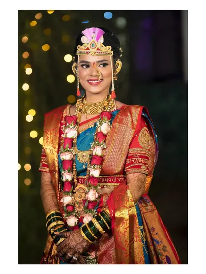 A radiant Maharashtrian bride. This portrait captures her beautiful smile and the complete traditional look, from her jewelry to her embroidered saree.