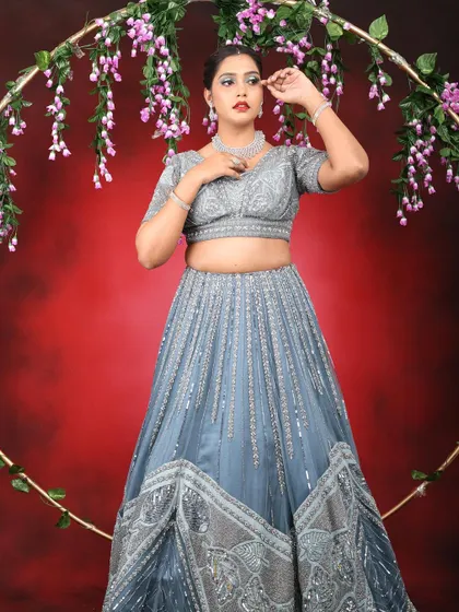 A full-length shot of the model in her elegant lehenga, framed by a floral ring. The makeup is glamorous and perfect for a party.