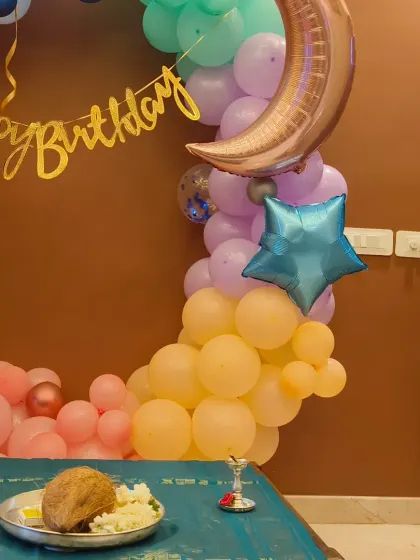 A whimsical moon and stars themed decoration for a fourth birthday. The pastel balloon ring is accented with a crescent moon and star foil balloons for a magical touch.