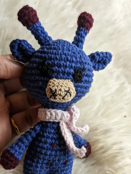 A custom-colored giraffe in blue with a soft pink scarf.