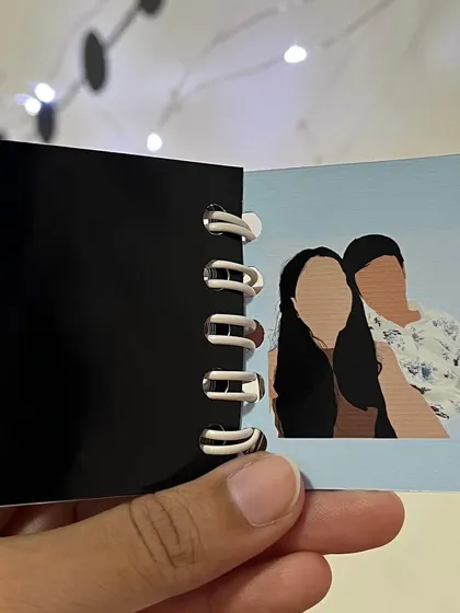 A page inside the mini booklet keychain, featuring a faceless illustration of the couple.