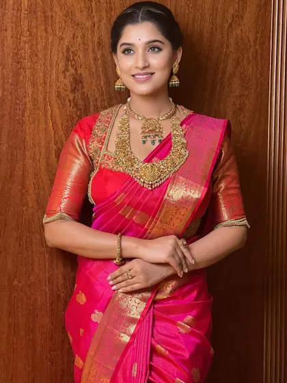 This look is all about festive elegance. The bright pink saree is paired with a classic makeup look, featuring a defined eye and a complementary lip color, perfect for any celebration.