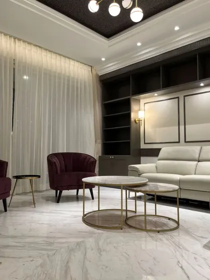 Sitting pretty has never been so easy! This living room is sofa-king stylish, with its marble floors, plush seating, and dramatic dark shelving.