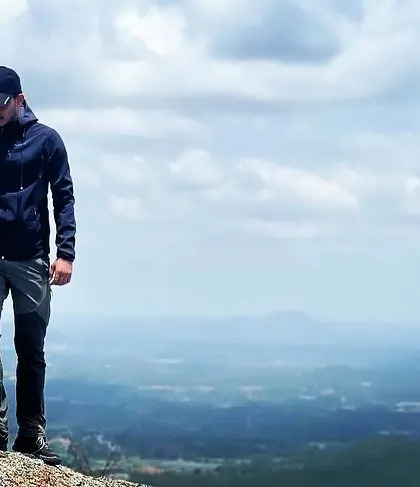 A solitary moment on the edge of Shivagange hill, showcasing the vastness of the view.