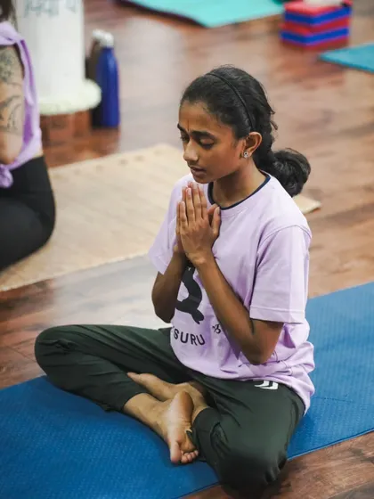 A young student finds a moment of stillness and prayer, showing that the principles of yoga are for every age and every body.